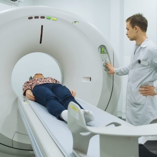 Male doctor exminating woman on mri machine